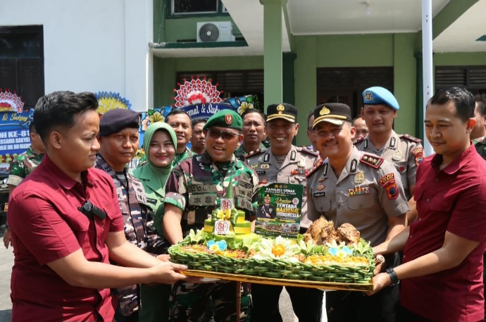 Kapolres Demak, AKBP Arrizal Samelino Gandasaputra memotong nasi tumpeng yang kemudian diberikan kepada Dandim 0716/Demak.