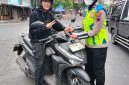Anggota Satlantas Polres Demak menyosialisasikan Operasi Patuh Candi 2026 dengan membagikan pamflet kepada pengguna kendaraan,  Selasa (28/10/2026).