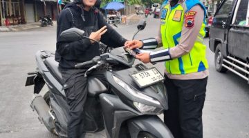 Anggota Satlantas Polres Demak menyosialisasikan Operasi Patuh Candi 2026 dengan membagikan pamflet kepada pengguna kendaraan,  Selasa (28/10/2026).