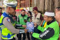 Anggota Satlantas Polres Demak 
 mengedukasi Pengemudi Ojol yentang keselamatan berkendara.
