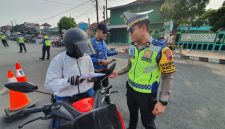Anggota Satlantas Polres Demak mensosialisasikan tertib berlalu lintas dan pembayaran pajak kendaraan bermotor di kawasan Alun-alun Demak, Jum'at (30/10/2026).