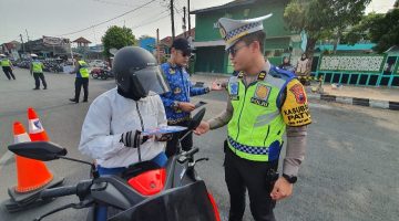 Anggota Satlantas Polres Demak mensosialisasikan tertib berlalu lintas dan pembayaran pajak kendaraan bermotor di kawasan Alun-alun Demak, Jum'at (30/10/2026).